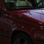 En röd bil parkerad i garagen. (AI text)