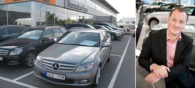 En man i kostym står bredvid en bil, intill honom står en annan man i kostym. (AI text)