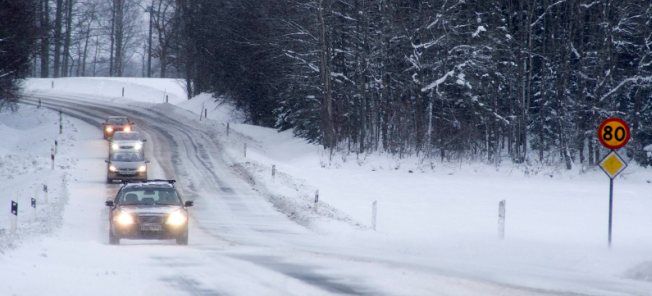 En bil körer nerför en snöig väg. (AI text)