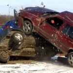 En bil ligger uppochnersad i en snöig åker. (AI text)