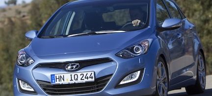 En blå Hyundai i30 kör nerför en landsväg. (AI text)