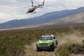 En helikopter flyger över en rallybil. (AI text)
