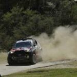 En rallybil körer längs en grusväg. (AI text)