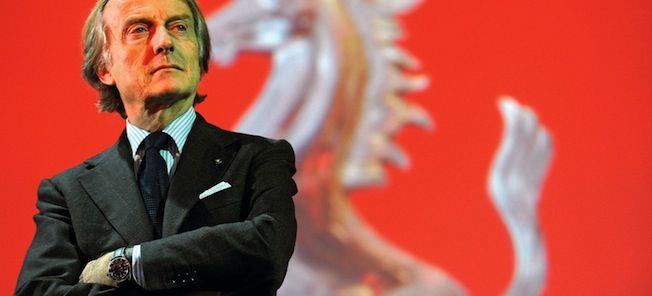 En man i kostym står framför en Ferrari-flagga. (AI text)