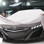 Två kvinnor står bredvid en bil. (AI text)