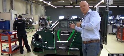 En man står bredvid en grön sportbil. (AI text)