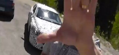 En person vinkar med sin hand i luften medan han kör bil. (AI text)