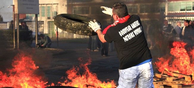 En man kastar en däck i en eld. (AI text)