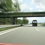 En bil kör på en motorväg. (AI text)