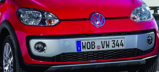 En röd Volkswagen up! parkerad vid en gata. (AI text)