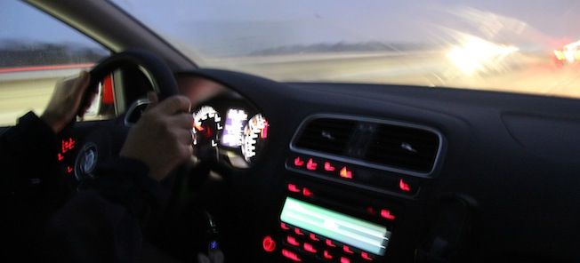 En man kör en bil i regnet. (AI text)