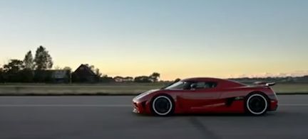 En röd sportbil kör längs en väg. (AI text)