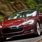 En Tesla Model S kör nerför en väg. (AI text)