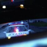 En polisbil återspeglad i en backspegel. (AI text)