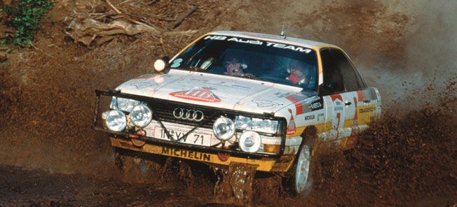 En Audi A3 rallybil körs genom smut.

Rättad version: En Audi A3 rallybil kör genom myrar. (AI text)