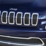 En man lastar en ny Jeep Cherokee på en släp. (AI text)