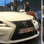 En man och kvinna står bredvid en vit bil. (AI text)