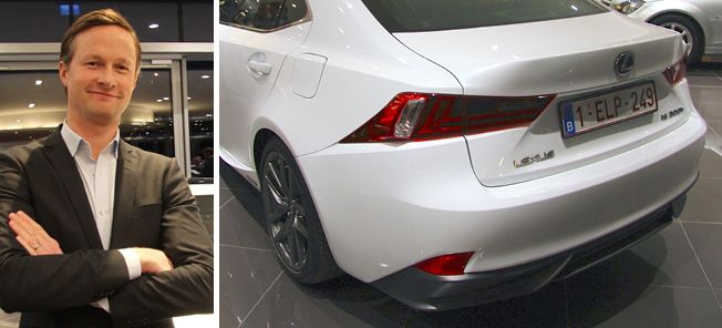 En man i kostym står bredvid en vit bil. (AI text)