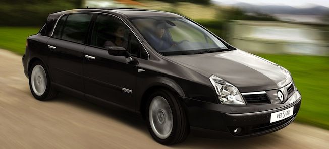 En svart bil kör längs en landsväg. (AI text)