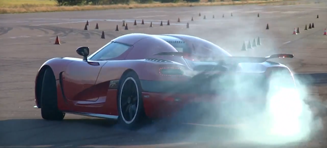 En röd sportbil kör längs en bana. (AI text)