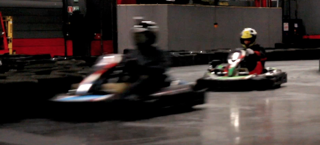 En grupp personer tävlar i gokarts på en inomhusbana. (AI text)