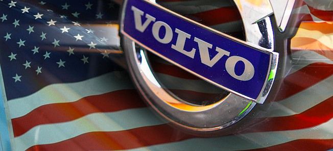 En Volvo XC90 med det amerikanska flagget på grille. (AI text)