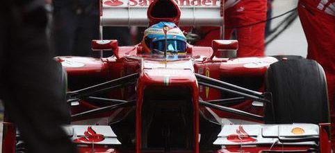 En Ferrari F1-bil står parkerad i depån. (AI text)