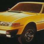 En gul bil mot en svart bakgrund. (AI text)