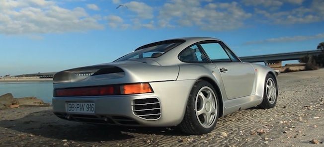 En silverfärgad Porsche 911 parkerad på en strand. (AI text)