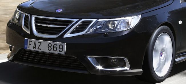 En svart bil kör nedför en väg. (AI text)