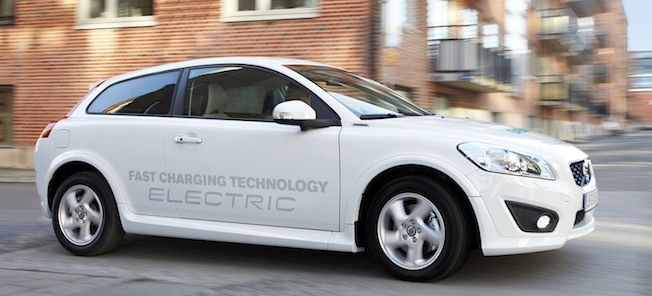 En vit bil kör ner en gata. (AI text)