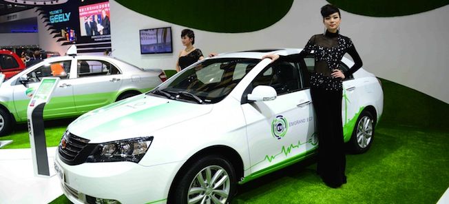 En kvinna står bredvid en bil vid en bilmesse. (AI text)