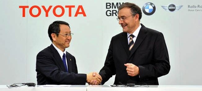 Två män skakar hand vid en Toyota GM presskonferens. (AI text)