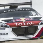 En rallybil kör nedför en backe. (AI text)