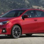 En röd Toyota Corolla kör nedför en bergsväg. (AI text)