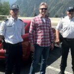 Tre polisbefäl står bredvid en bil. (AI text)