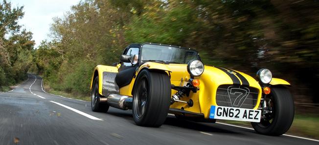 En gul sportbil körer längs en landsväg. (AI text)