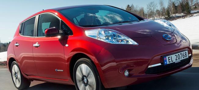En röd Nissan Leaf kör nedför en snöig väg. (AI text)