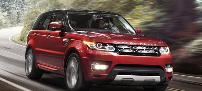 En röd Land Rover kör nerför en väg. (AI text)