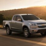 En Chevrolet Colorado-lastbil kör längs en landsväg. (AI text)