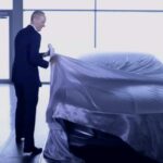 En man står framför en bil. (AI text)