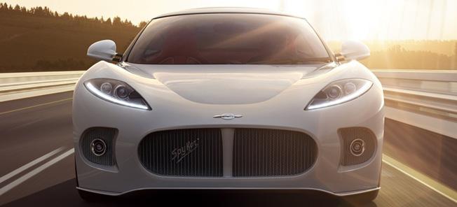 En vit sportbil kör nedför en motorväg. (AI text)