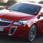 En röd Opel Astra kör nedför en väg. (AI text)