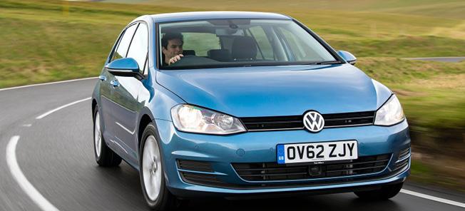 En blå Volkswagen Golf kör nerför en landsväg. (AI text)