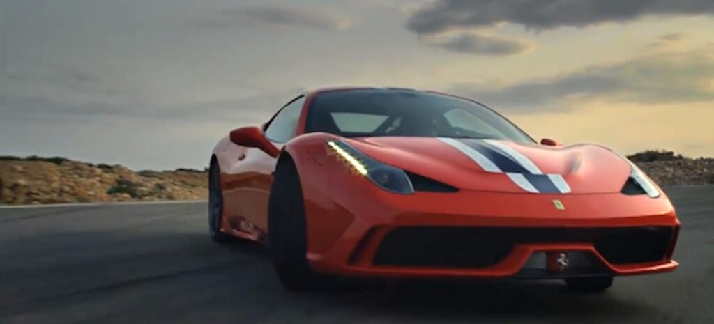 En Ferrari 488 Spider kör nedför en väg. (AI text)