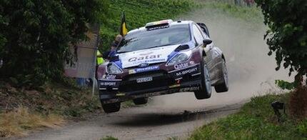 En Ford Fiesta rallybil i luften. (AI text)