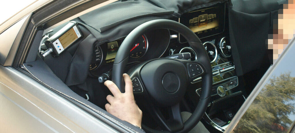 En man sitter i förarsätet i en bil. (AI text)