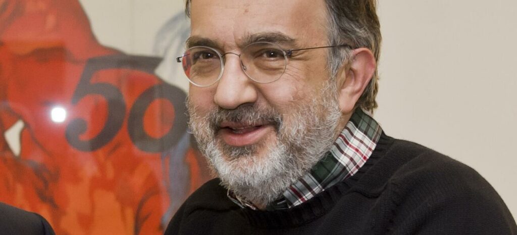 Två män i kostym står bredvid en bil. (AI text)