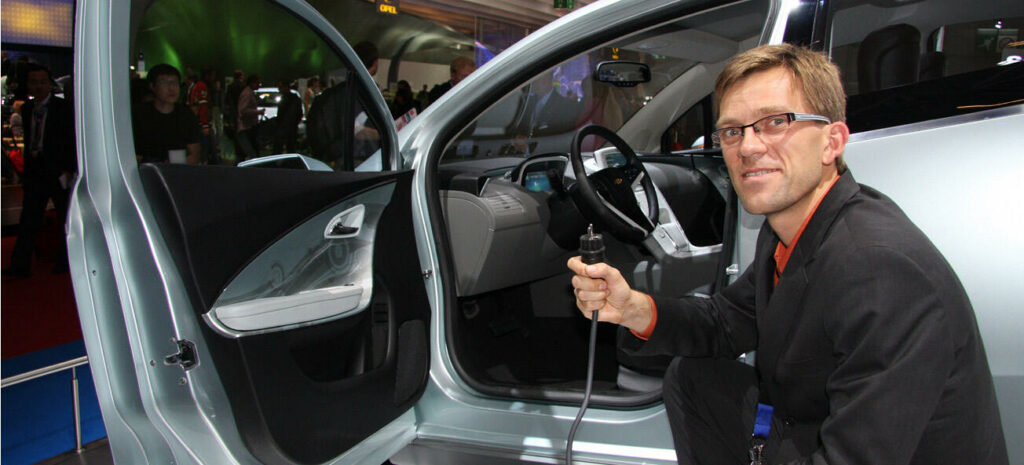 En man öppnar dörren till en bil. (AI text)