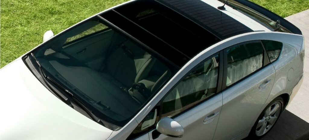 En vit bil står parkerad på en uppfart. (AI text)